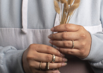 <Img alt=" A portrait of model holding plant to show off rings">