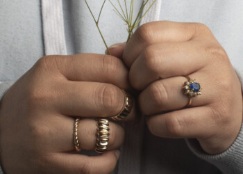 <Img alt=" picture of models hand holding babies breath showing off rings">